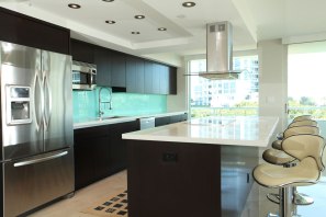 Modern kitchen in dark finish with white bench tops
